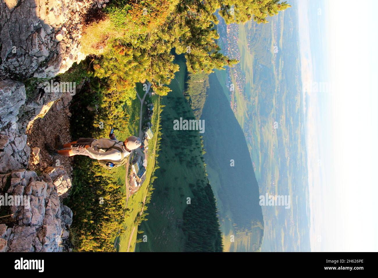 jeune homme en randonnée au sommet de kampenwand (1669 m) à chiemgau, téléphone cellulaire, tour, gps, lever du soleil, alpes de chiemgau, chiemsee, près d'aschau, haute-bavière, bavière, sud de l'allemagne, allemagne Banque D'Images