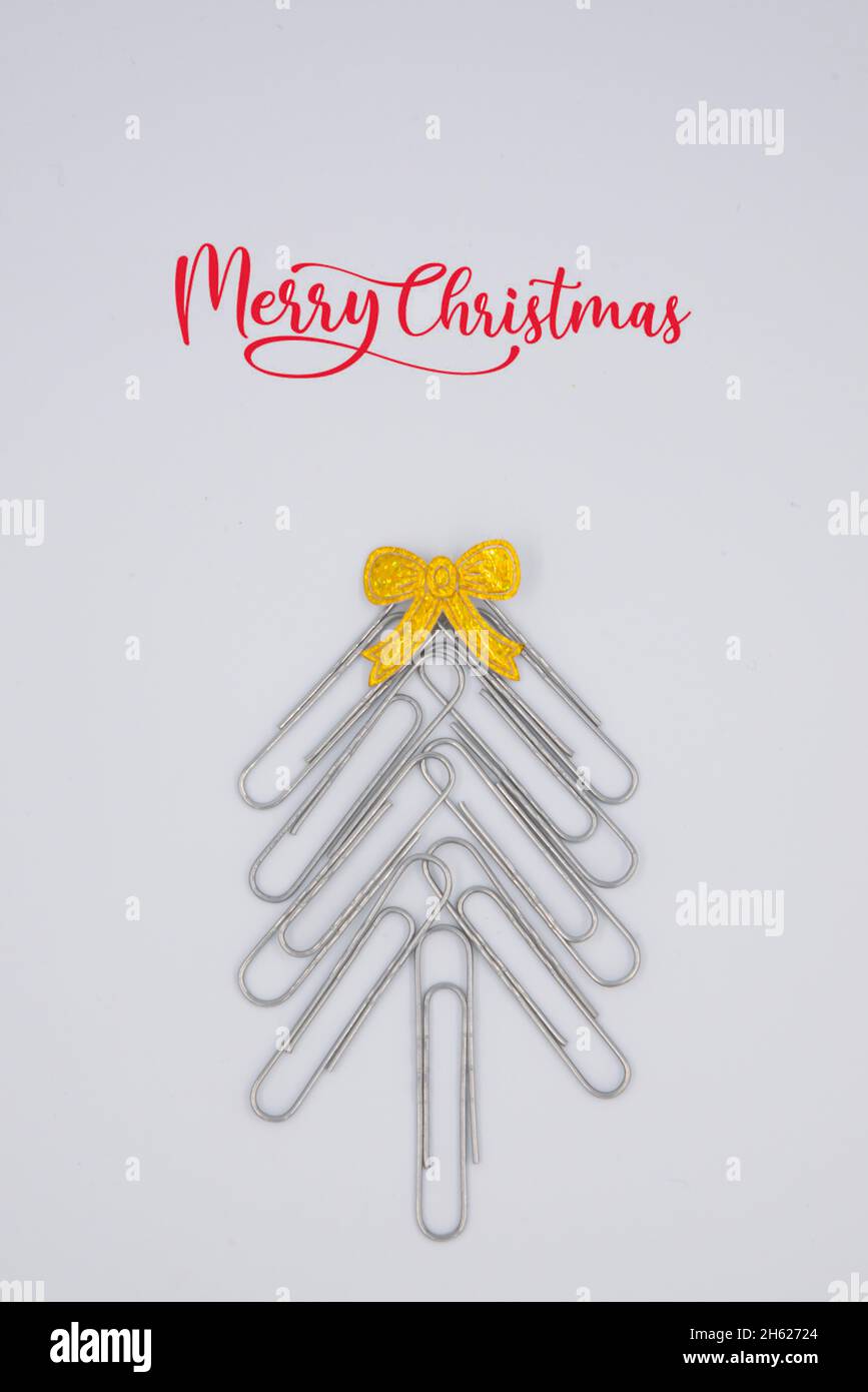Concept joyeux Noël au bureau.Arbre de Noël fait de trombones sur fond blanc. Trombone arbre de Noël.Arrière-plan de Noël. Banque D'Images