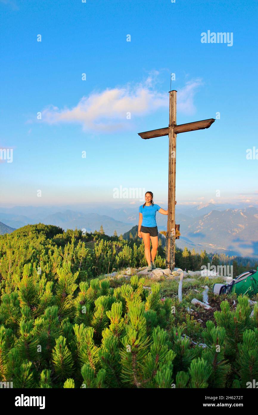 jeune femme à la croix du sommet,randonnée à l'écart 1829m,montagnes d'ester,coucher de soleil,pins de montagne,pin de montagne,pinus mugo,vue sur les montagnes de karwendel,europe,allemagne,bavière,haute-bavière,werdenfelser land,alpenwelt karwendel,isar vallée,krün Banque D'Images