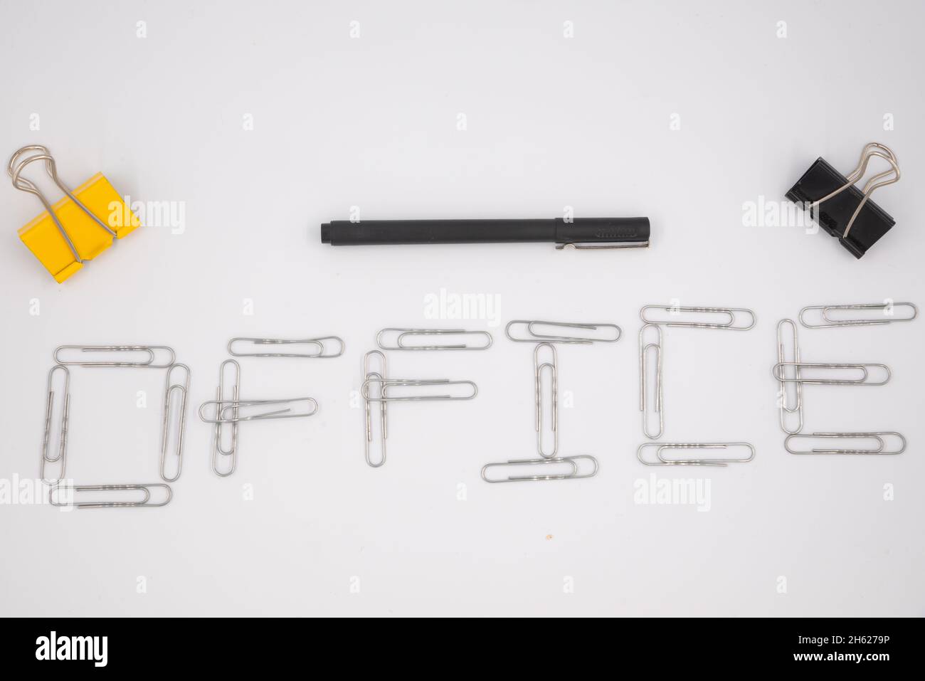 « Office » écrit avec des trombones métalliques sur le fond blanc.Pose à plat.Restez à la maison.Travail à distance.Enseignement à distance.Quarantaine.Auto-isolation. Banque D'Images