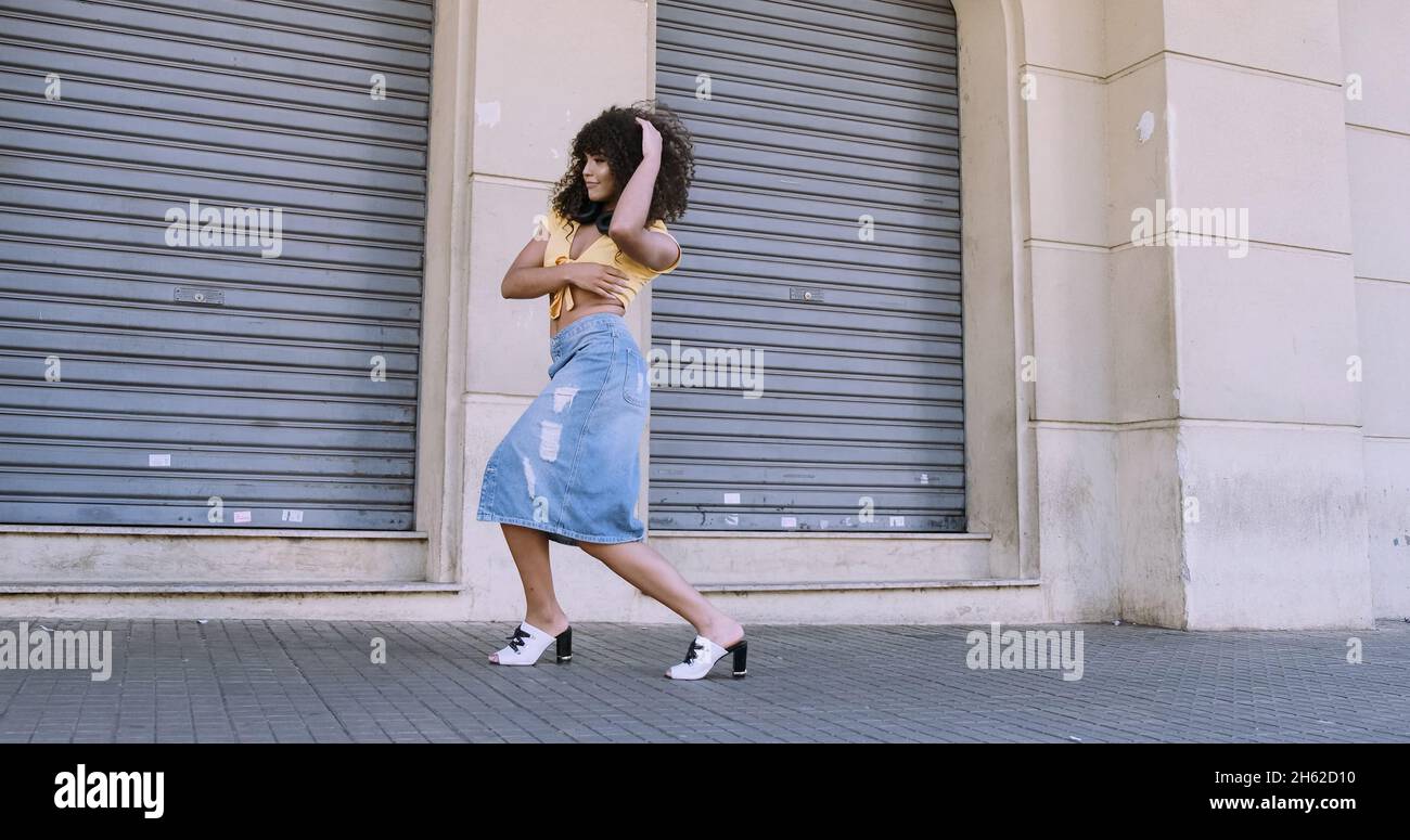 Danseuse de style moderne avec afro sur sa tête dansant dans la rue Banque D'Images