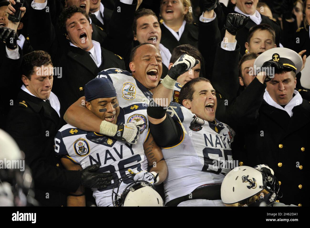 Plusieurs membres de l'équipe de football de la Marine se joignent aux midshipmen dans les tribunes pour célébrer après le match de football Armée contre Marine au Lincoln Financial Field le 8 décembre 2012. Banque D'Images