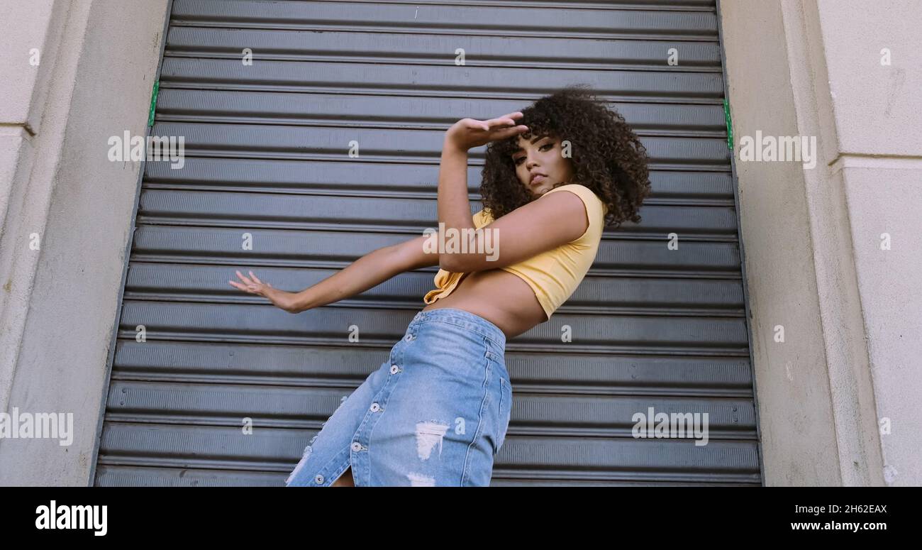 Danseuse de style moderne avec afro sur sa tête dansant dans la rue Banque D'Images