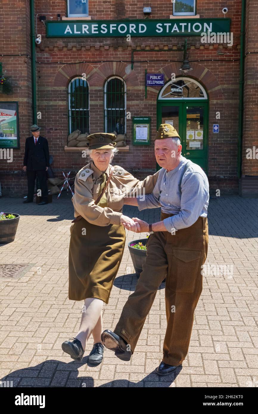 angleterre,hampshire,aylsford,gare d'aylsford,le chemin de fer du patrimoine de mid-hants alias la ligne de cresson, couple de personnes âgées vêtues d'uniformes de la seconde guerre mondiale britannique dansant en face de la gare d'aylsford pendant le festival annuel de la « guerre sur la ligne » Banque D'Images