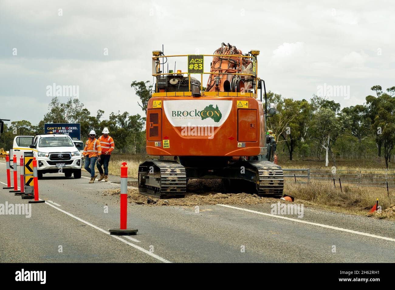 Bruce Highway Mackay à Townsville, Queensland, Australie - novembre 2021 : ouvriers de la construction à côté d'une énorme machine effectuant des travaux de terrassement sur la construction de l'autoroute Banque D'Images