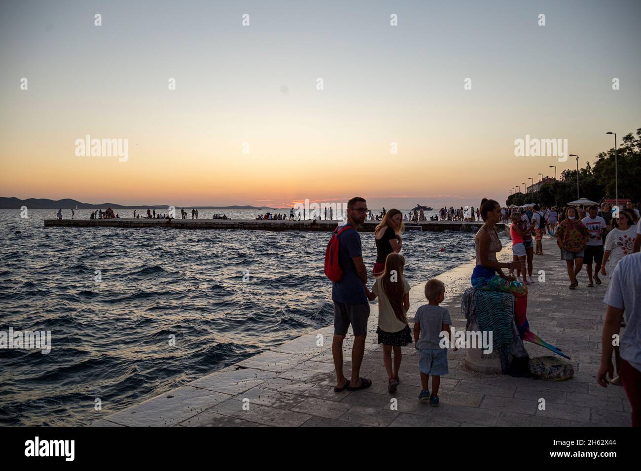 personnes debout sur une jetée au coucher du soleil à zadar,dalmatie,croatie Banque D'Images
