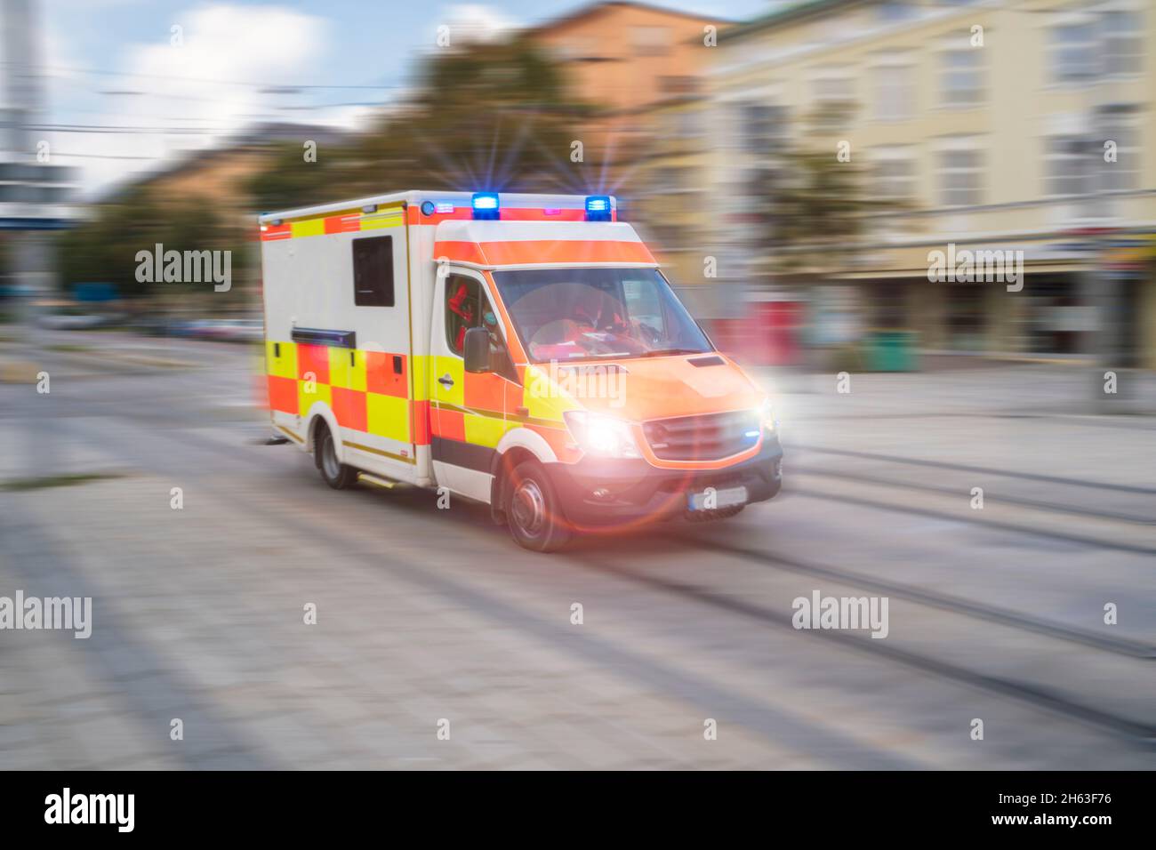 une ambulance traverse la ville avec des feux clignotants et une grande vitesse Banque D'Images