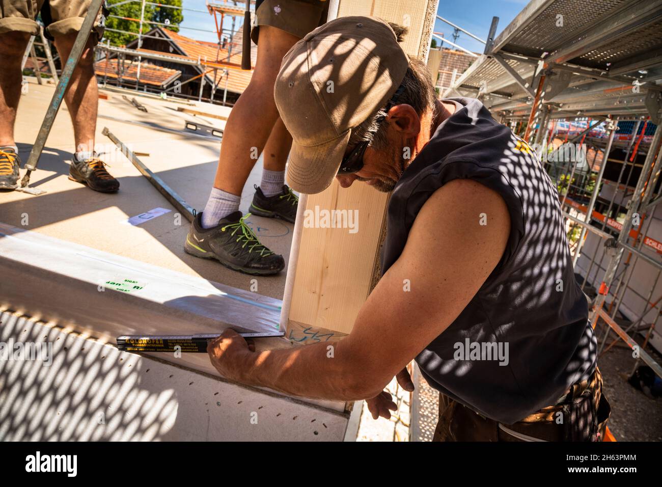 allemagne,bavière,construction d'une maison préfabriquée en bois, le menuisier mesure la distance lors de l'installation du mur, Banque D'Images