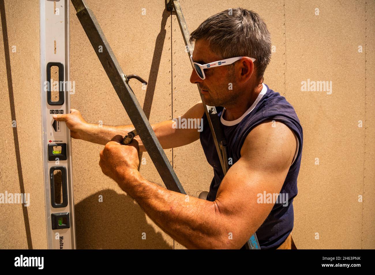 allemagne,bavière,construction d'une maison préfabriquée en bois, mesurant avec un niveau à bulle lors de l'installation d'une cloison, Banque D'Images