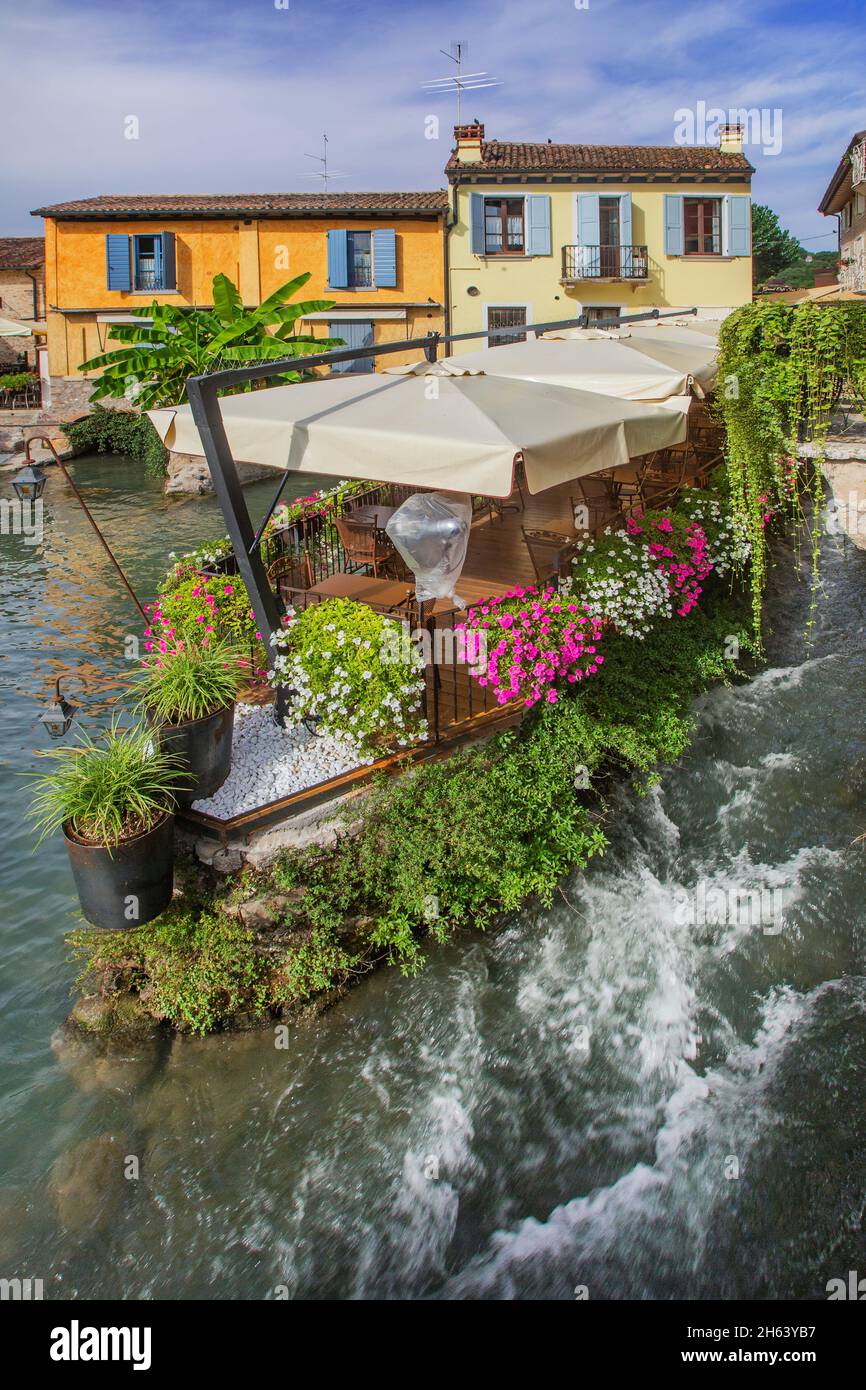 terrasse de restaurant avec fleurs sur la rivière mincio, borghetto, quartier de valeggio sul mincio, village du moulin, vallée po, province de vérone, vénétie, italie Banque D'Images