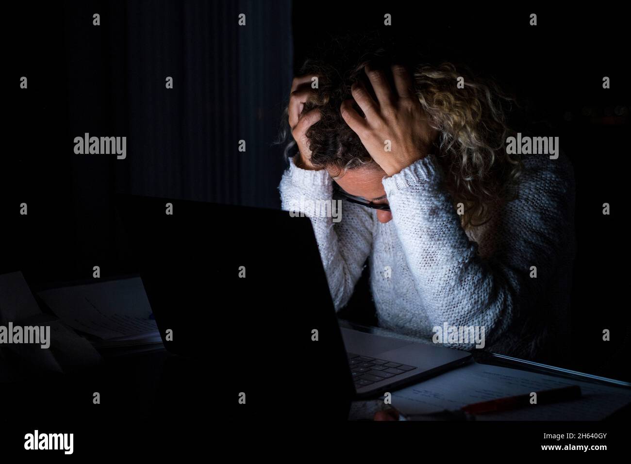 femme fatiguée et frustrée travaillant et utilisant un ordinateur portable tard dans la nuit. femme d'affaires contrariée d'avoir trop de travail Banque D'Images