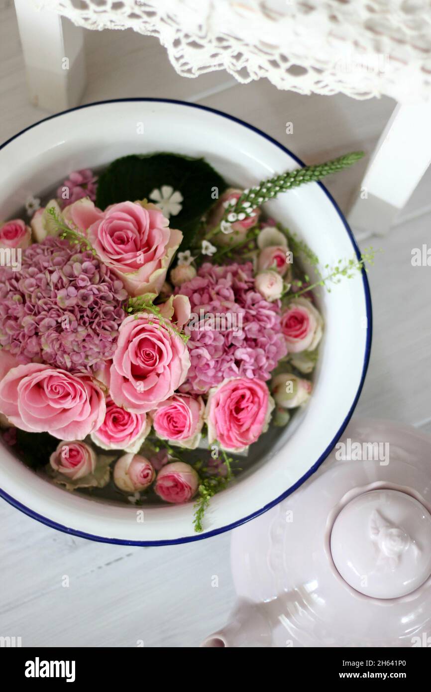 les fleurs flottent dans un bol d'eau Banque D'Images