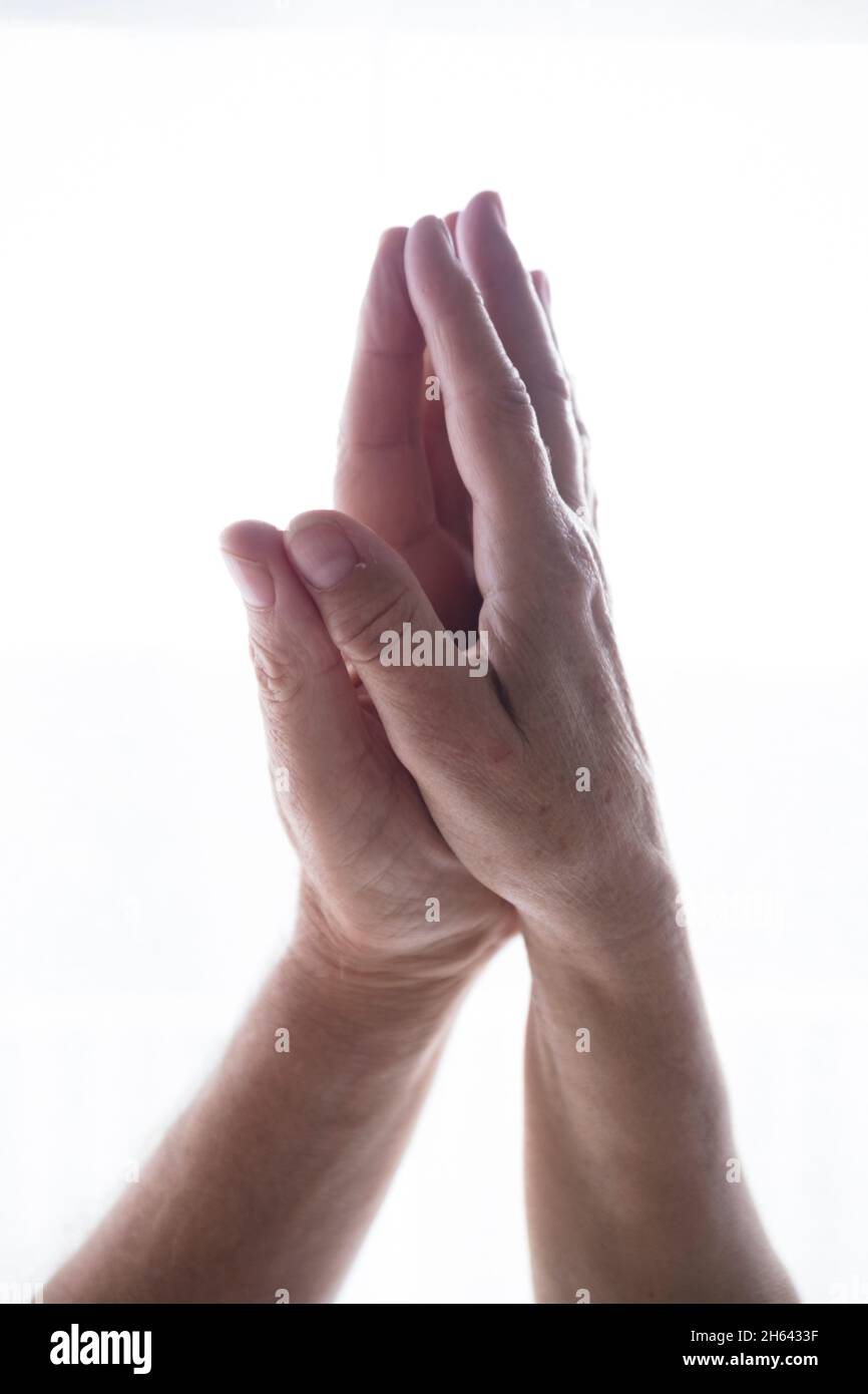 paume des mains humaines réunies en position de prière namaste sur fond d'espace de copie blanc. concept de bien-être et de style de vie sain. mains adultes faisant la méditation de yoga dans la pose de prière. Banque D'Images