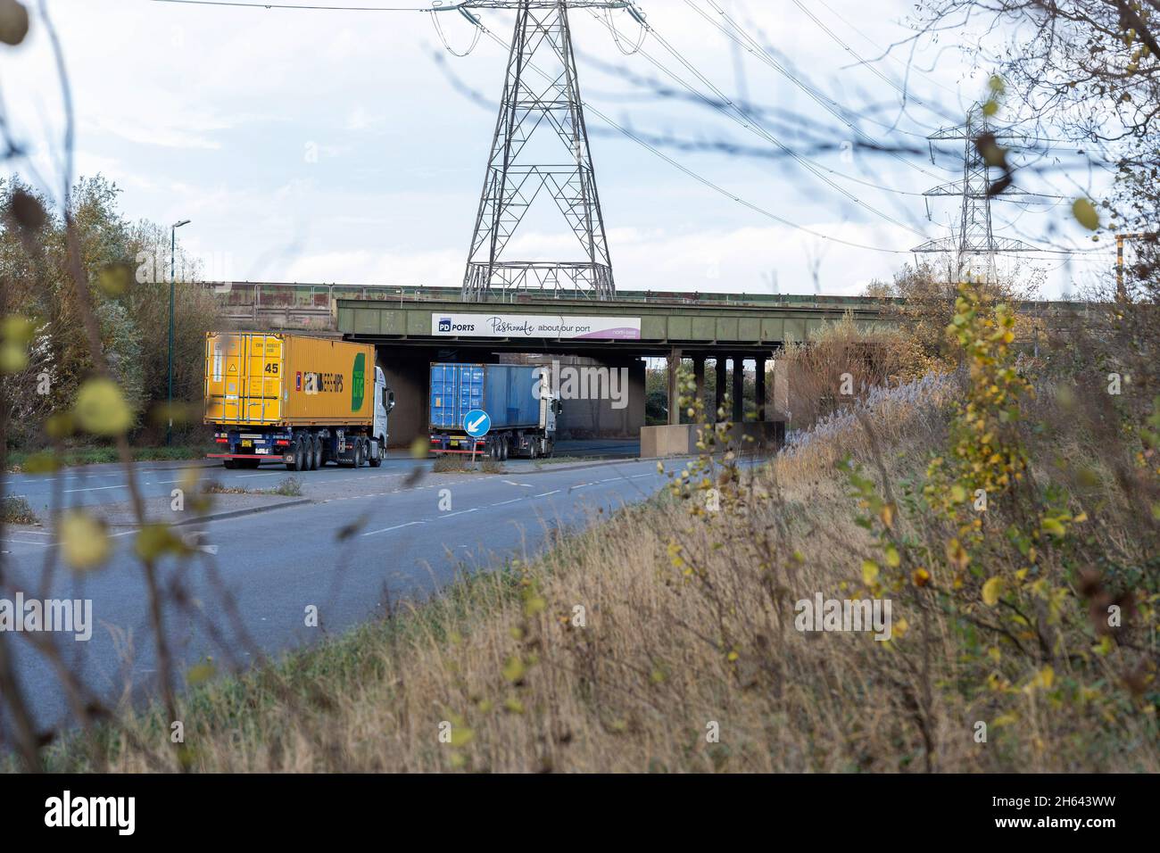 Deux véhicules lourds (HGV) se trouvent sous un pont de la marque PD ports à leur entrée dans Teesport à Middlesbrough. Les membres du syndicat Unite travaillant pour Svitzer Marine, qui exploite des remorqueurs sur la rivière Tees, ont été gonflés pour une action industrielle en réponse à un gel des salaires proposé par leur employeur.Le vote se termine le vendredi 12 novembre 2021, la grève commençant au début de décembre si les membres sont en faveur de l'action.Teesport est le cinquième plus grand port à conteneurs du Royaume-Uni et l'action industrielle pourrait mettre le port à l'arrêt dans les semaines précédant Noël.(Photo de Jason Brown/SOPA Images/Sipa USA) Banque D'Images