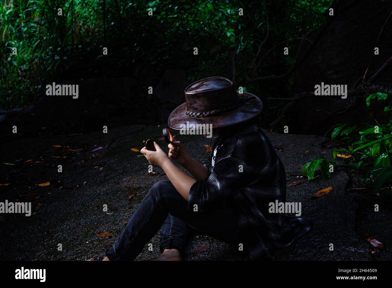 Fille étudiante faisant de la recherche dans la forêt comme le fond. Banque D'Images