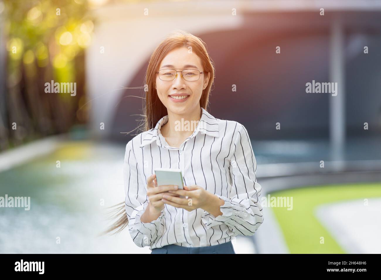 Portrait asiatique hommes d'affaires femmes adulte intelligente femme debout regardant un appareil photo avec un smartphone Banque D'Images