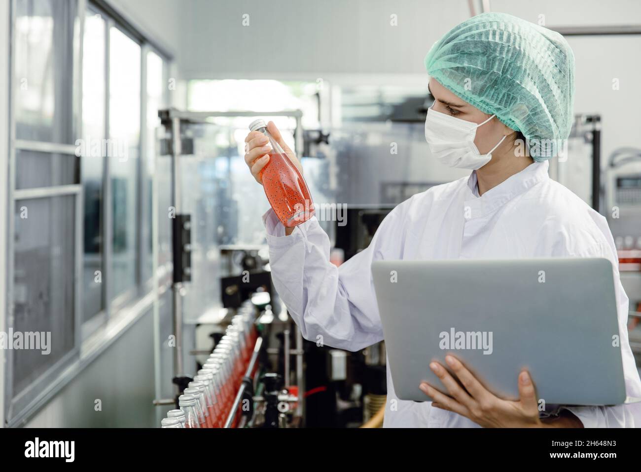 Les inspecteurs du contrôle de la qualité et de la sécurité alimentaire testent et vérifient les normes de contamination des produits dans la chaîne de production de l'usine d'aliments et de boissons avec des soins d'hygiène. Banque D'Images