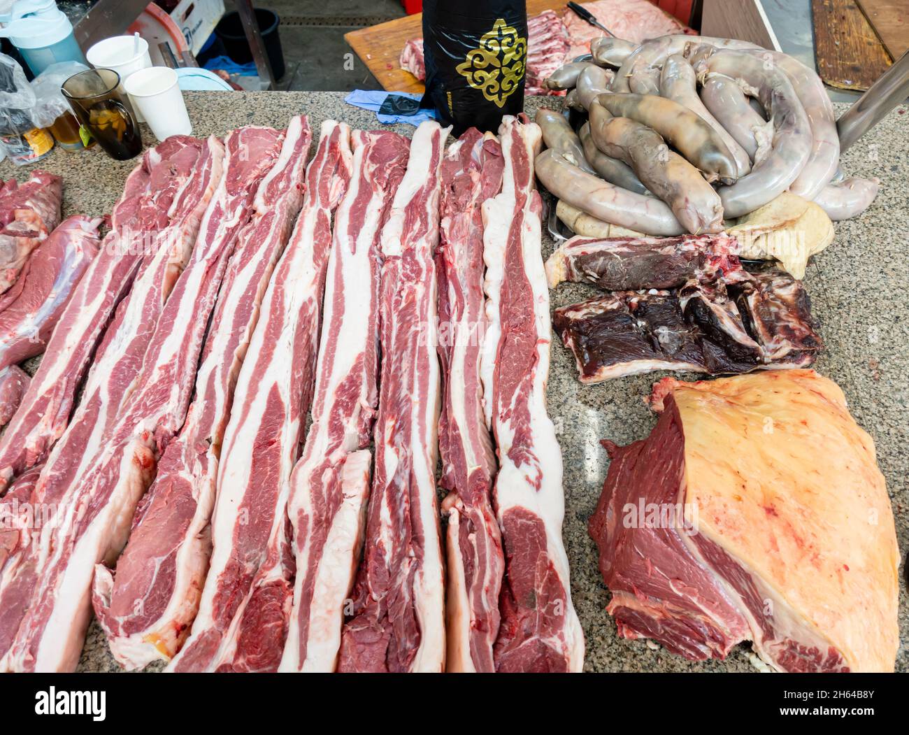 Couper des tranches de viande de cheval, qazy, saucisse de cheval o nthe comptoir dans le marché de la viande Altyn Orda, Almaty, Kazakhstan Banque D'Images