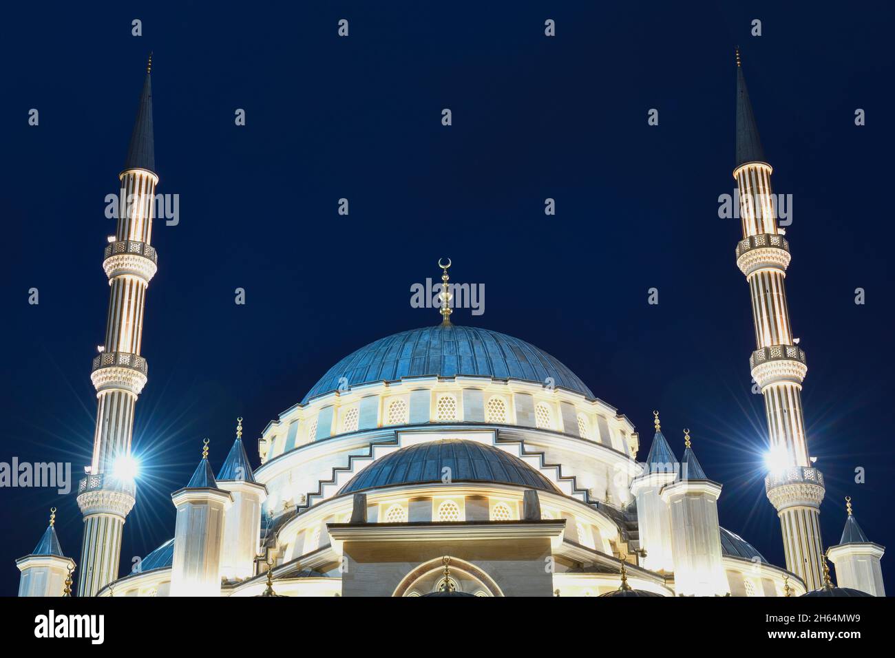 Dôme de la mosquée "coeur de la Tchétchénie" et deux minarets en gros plan dans l'illumination nocturne.Grozny, République tchétchène Banque D'Images