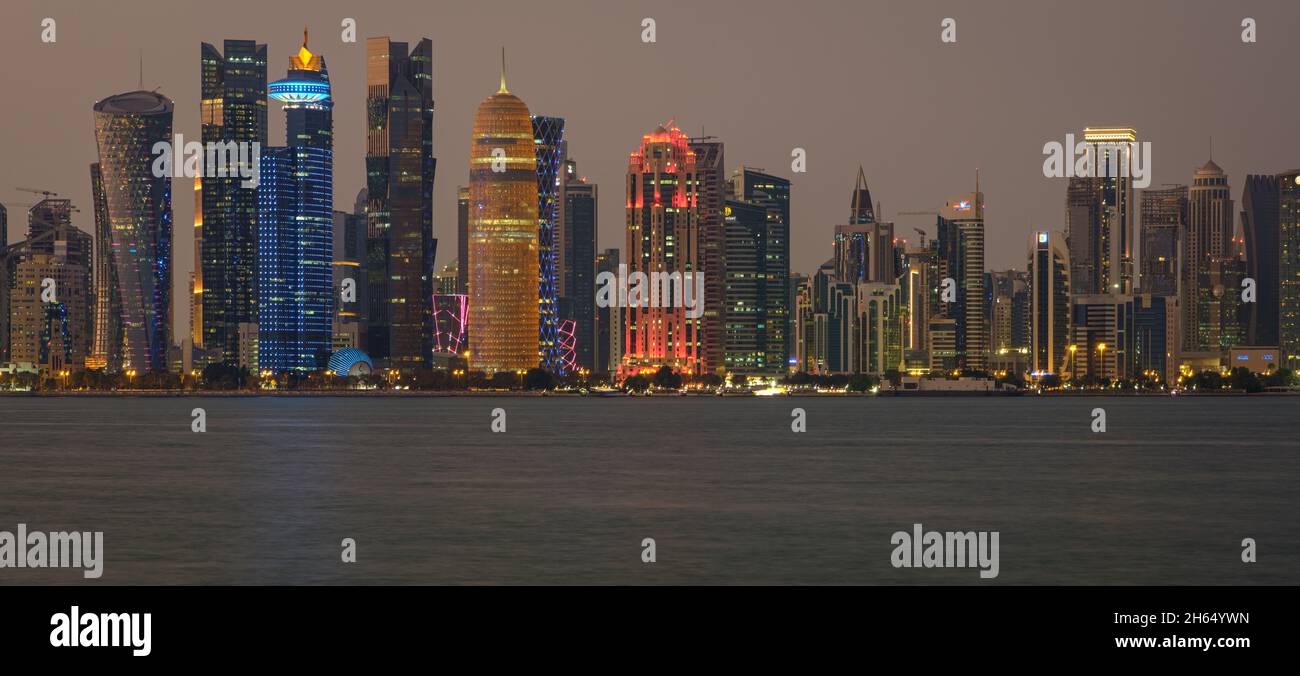 Doha Qatar skyline at night montrant les lumières des gratte-ciel reflétées dans le golfe Arabe Banque D'Images