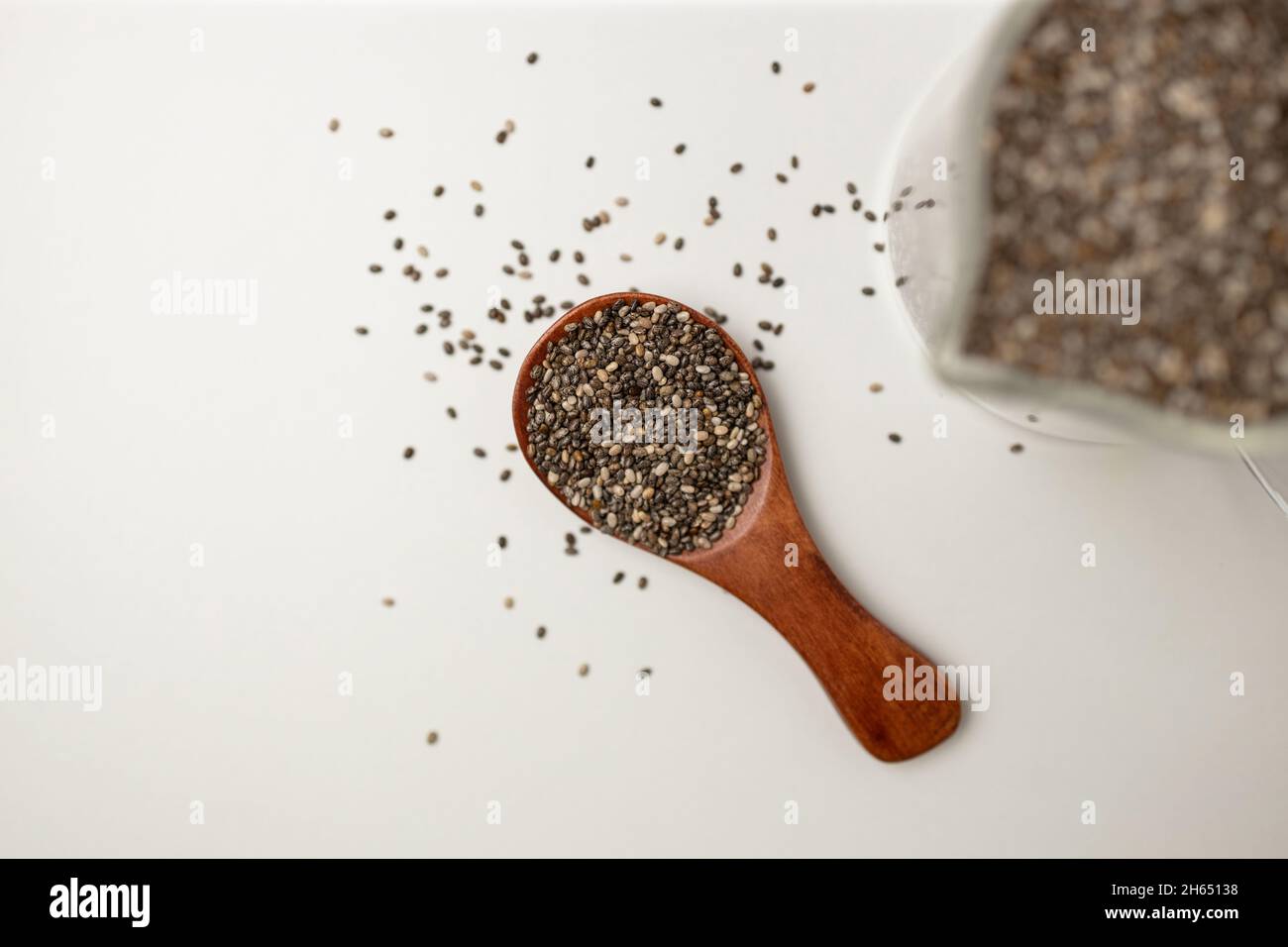 Graines de Chia en cuillère en bois et tasse de la vue de dessus avec espace sur fond blanc avec espace de copie, vue de dessus Banque D'Images