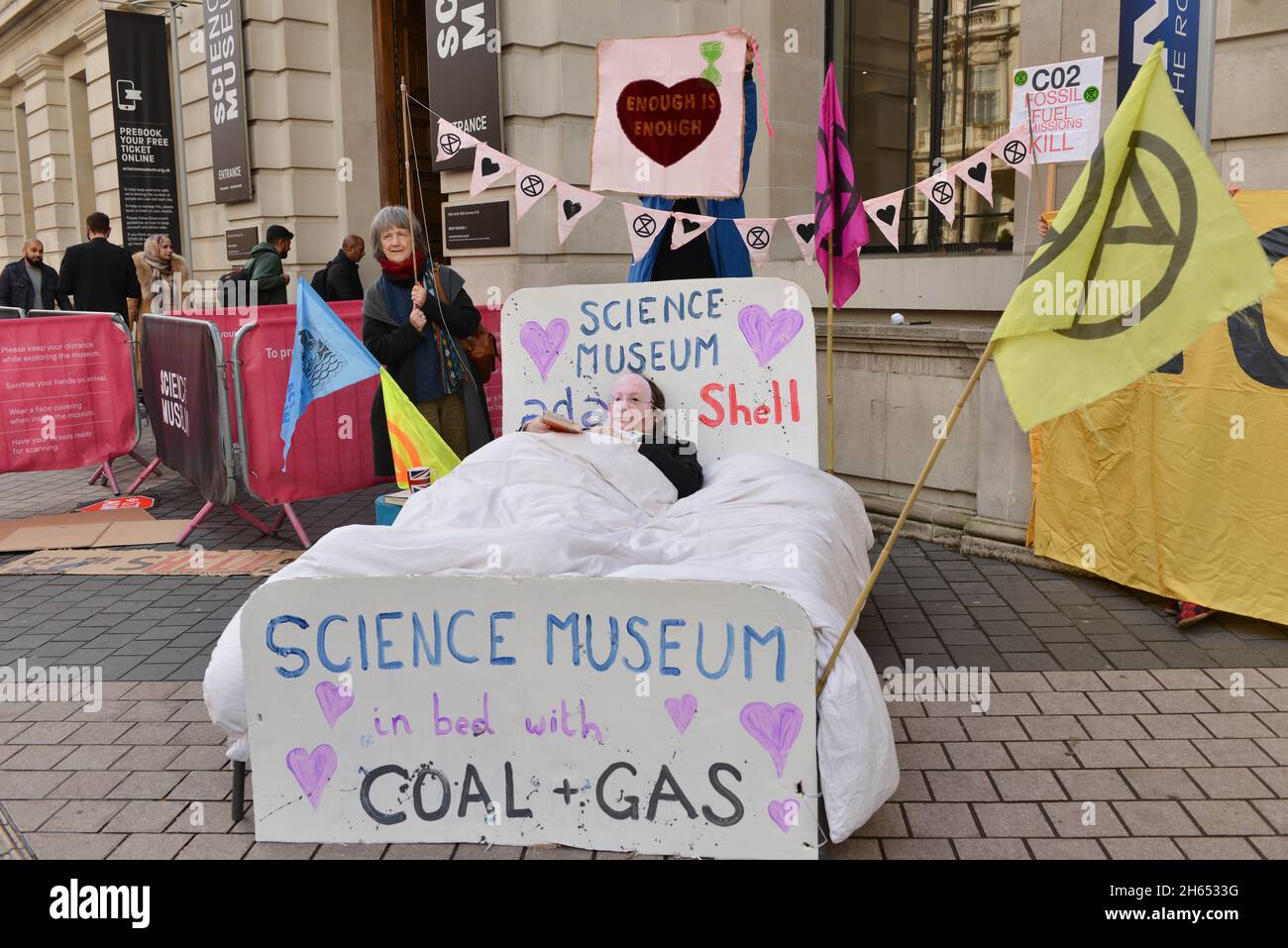 Un manifestant habillé comme directeur du Musée des Sciences Ian Blachford se trouve sur un lit pendant la démonstration.Extinction les militants de la rébellion ont organisé une manifestation en face du Musée des sciences de South Kensington contre le parrainage du musée par les sociétés de combustibles fossiles Shell et Adani. Banque D'Images