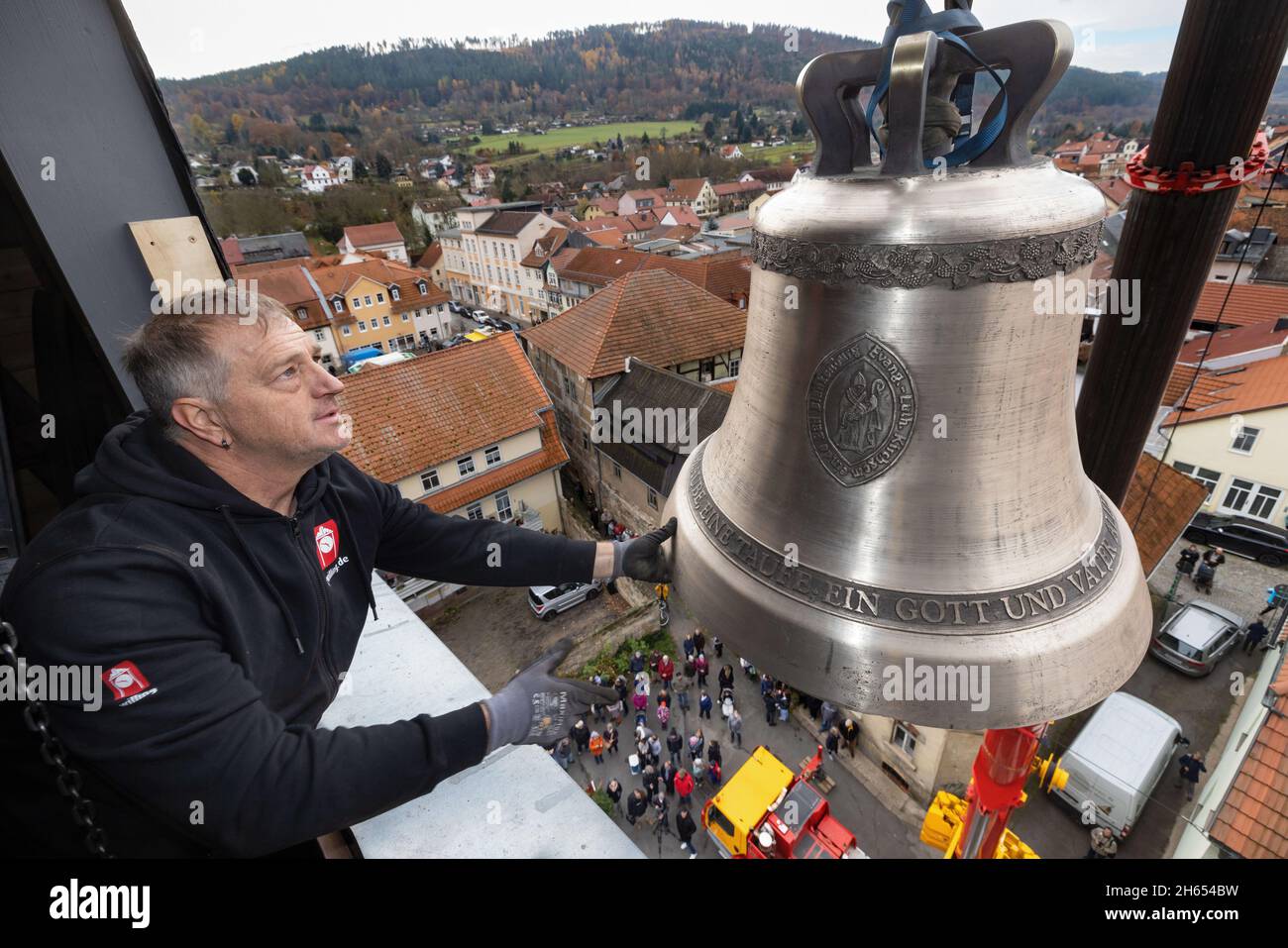 Bad Blankenburg, Allemagne.13 novembre 2021.Uwe Nothnagel utilise une grue pour soulever la première des deux nouvelles cloches dans la tour de l'église Saint-Nikolai.Les deux nouvelles cloches ont été décorées avec soin et consacrées à l'avance et conduits à travers la ville.Ils remplacent deux cloches en acier de presque 100 ans qui ne pouvaient plus être suspendues.Credit: Michael Reichel/dpa/Alay Live News Banque D'Images