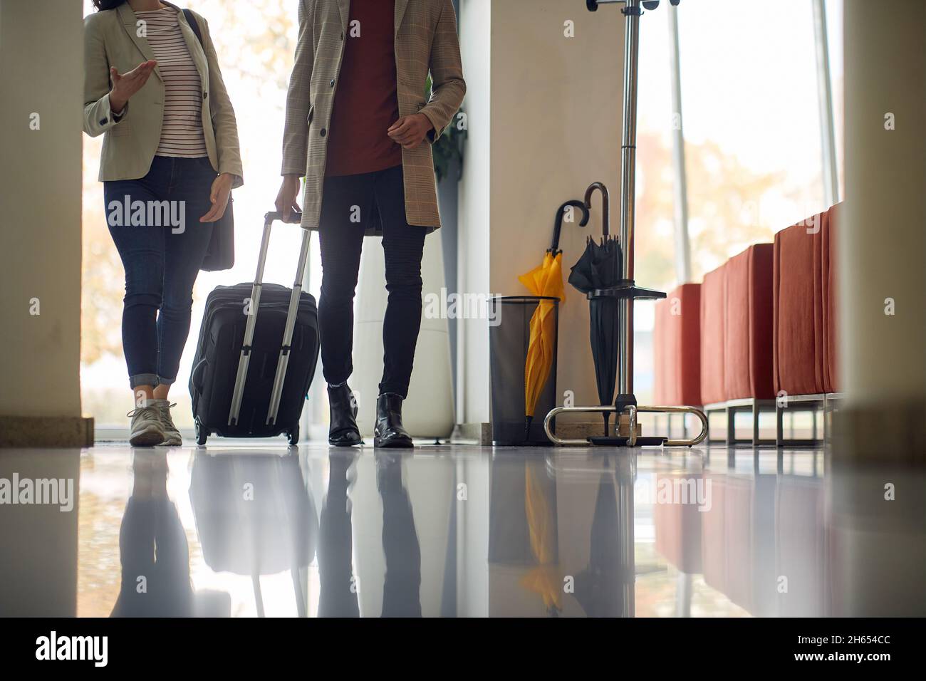 Homme et femme transportant des bagages dans le hall d'un hôtel.hommes d'affaires avec des bagages dans le hall Banque D'Images