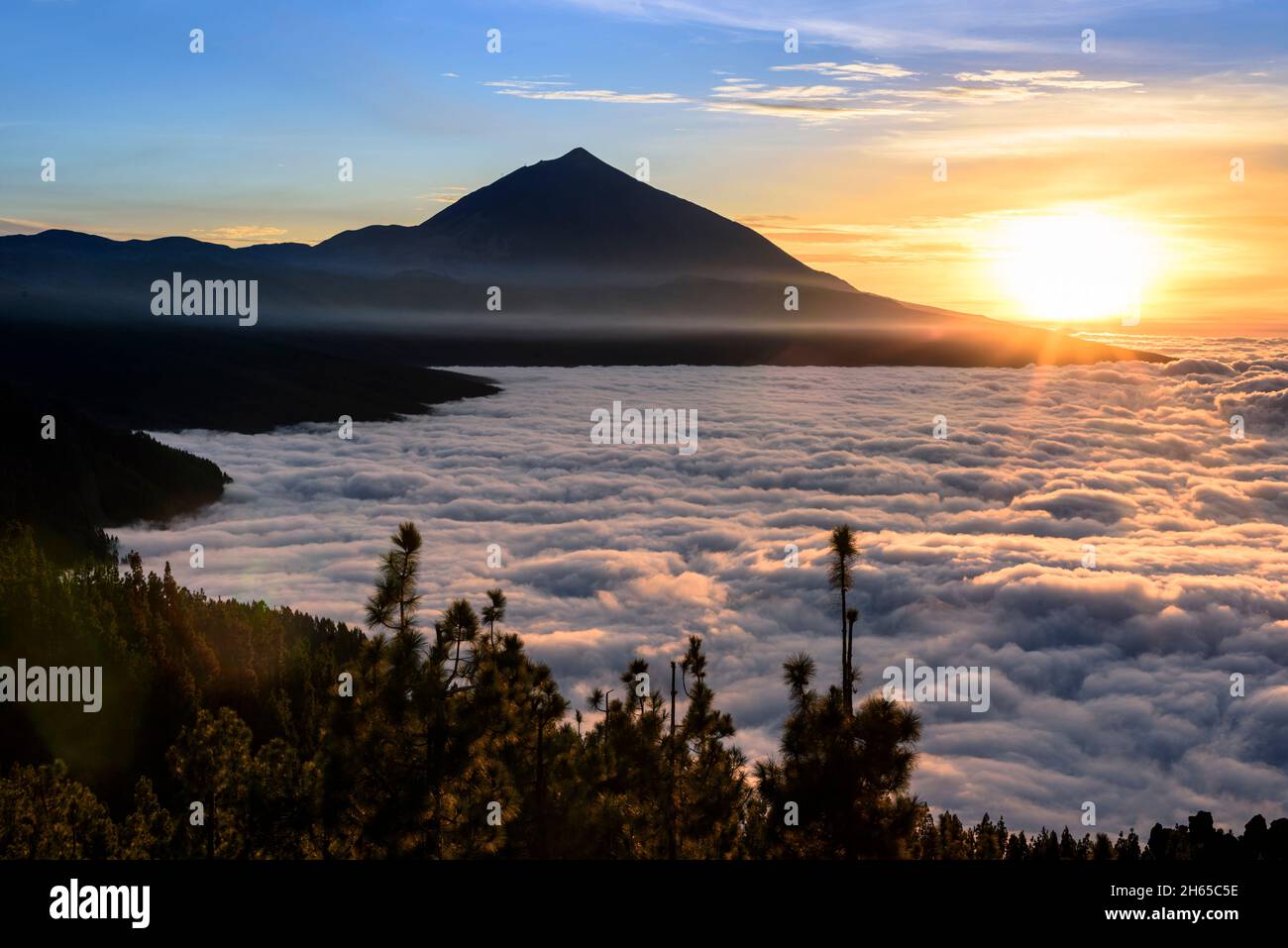 Le volcan Teide s'élève majestueusement au-dessus d'un lac dans la lumière du soir qui brille des nuages, Tenerife, Espagne Banque D'Images