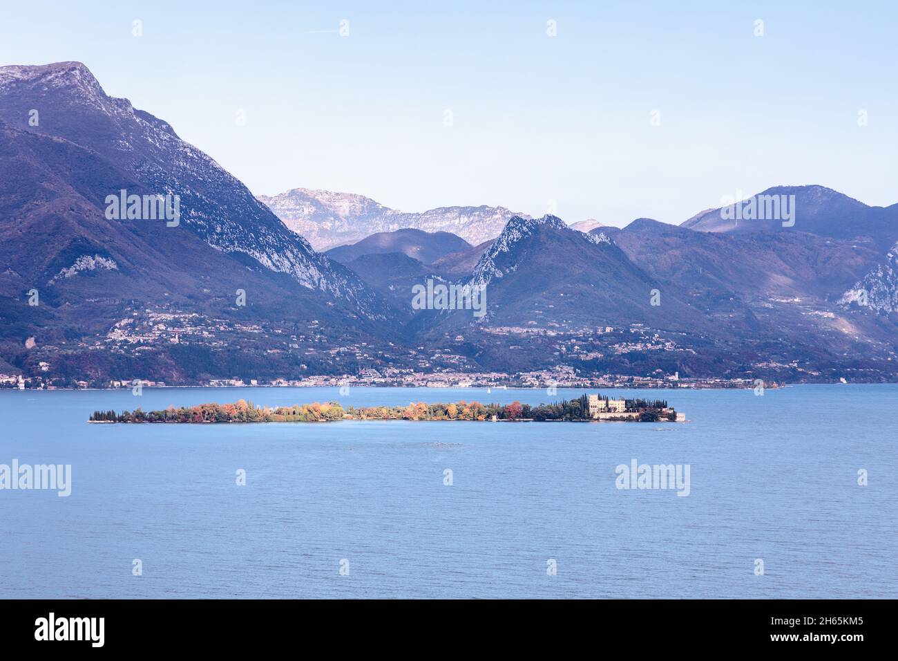 L'Isola del Garda ensoleillée (Borghese Cavazza) se trouve sous des crêtes montagneuses escarpées dans le lac de Garde près de San Felice del Benaco, Lombardie, Italie. Banque D'Images