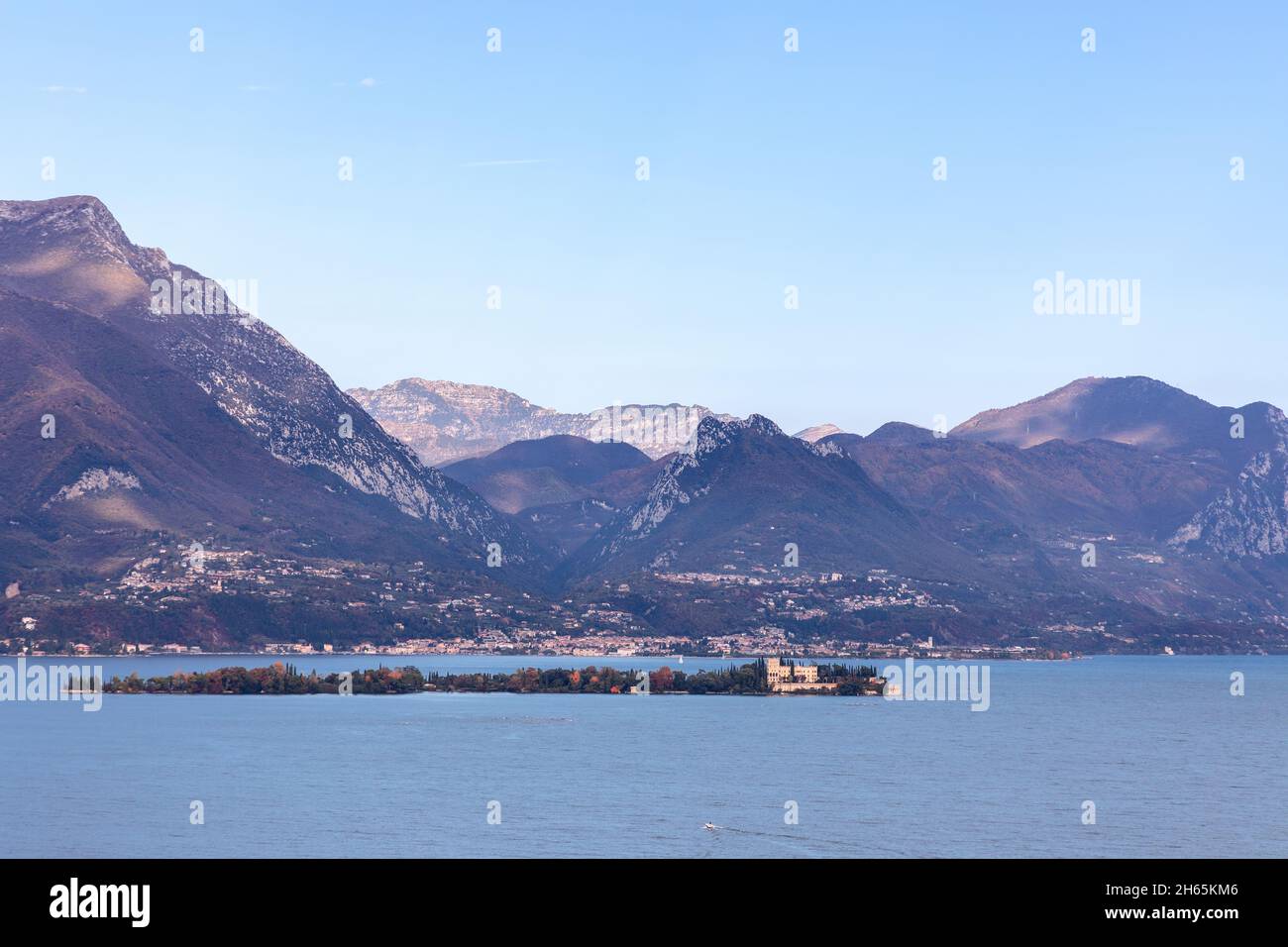 L'Isola del Garda boisée (Borghese Cavazza) et sa villa se trouvent en contrebas de montagnes escarpées près de San Felice del Benaco, Lombardie, Italie. Banque D'Images