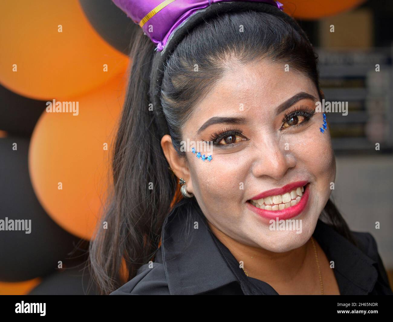 Jeune femme yucatecenne mexicaine gaie avec maquillage traditionnel et bijoux de visage/gemmes scintillants souriants le jour des morts (Día de los Muerto). Banque D'Images