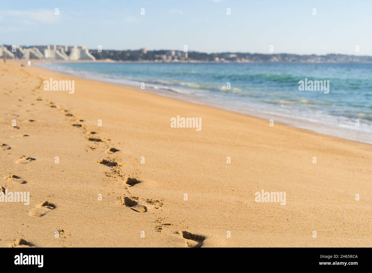 Empreintes de pas sur le sable à une plage vide avec un arrière-plan flou le jour ensoleillé à l'Algarve, au Chili.Solitude par le concept de la mer Banque D'Images