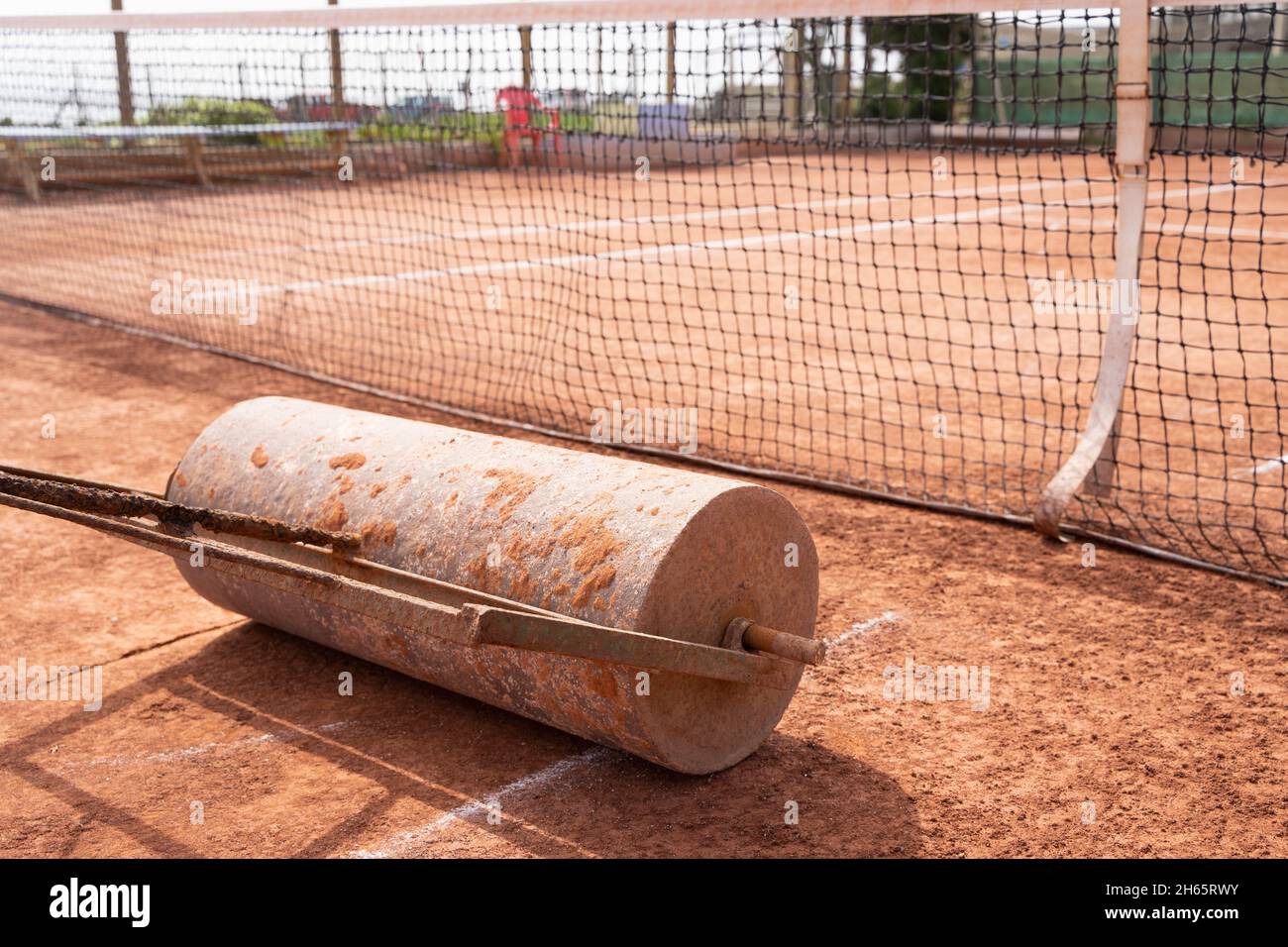 Des niveaux de rouleaux lourds sur le court de tennis en terre battue par temps ensoleillé à l'extérieur.Concept de maintenance des tournois sportifs Banque D'Images