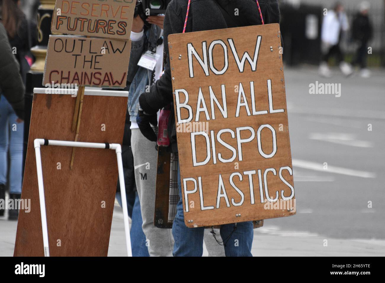 Un panneau de protestation tenu par un écoactiviste vert devant le Parlement de Westminster à Londres qui se lit comme suit : « maintenant, interdire tous les plastiques jetables » Banque D'Images