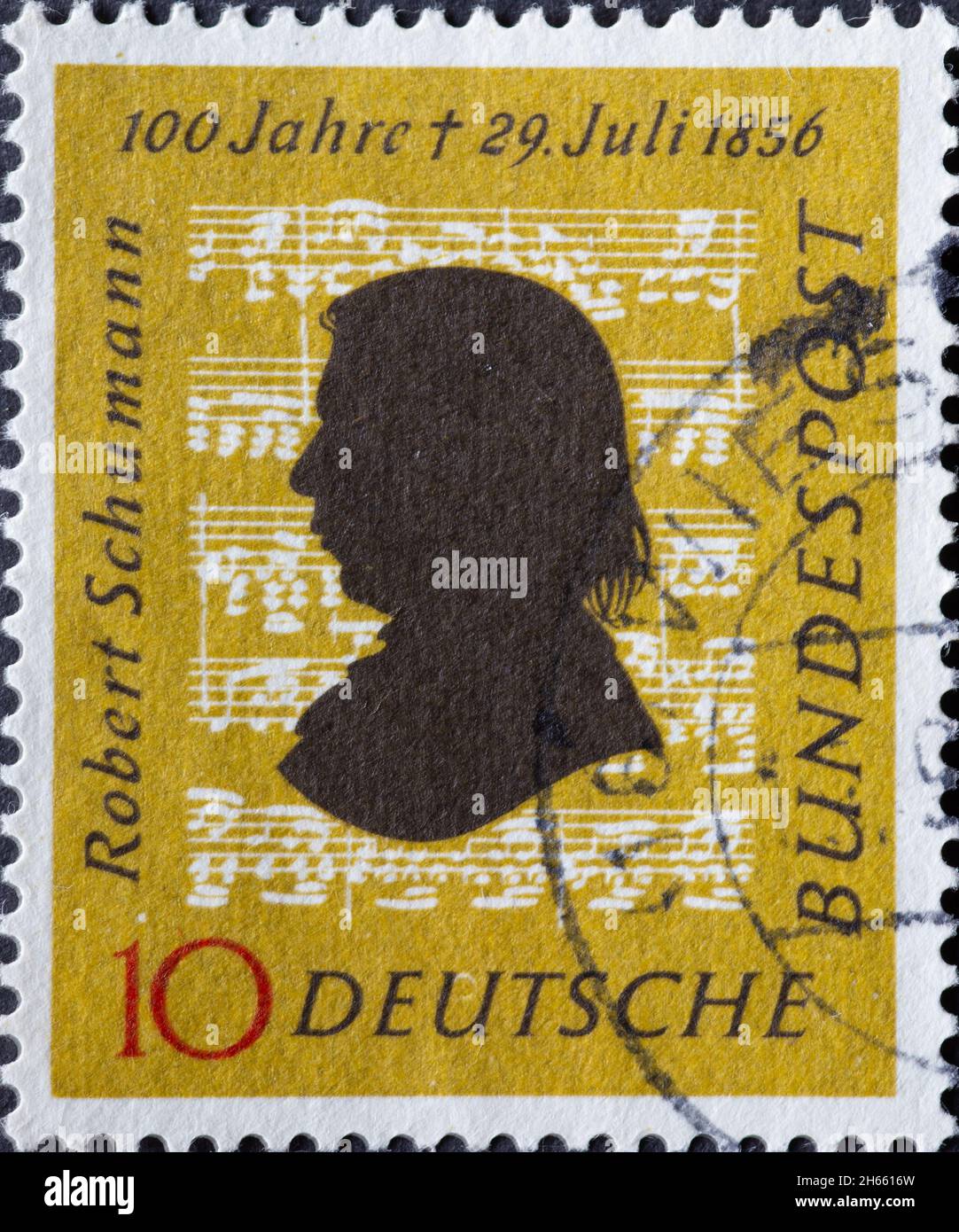 ALLEMAGNE - VERS 1956: Ce timbre-poste en jaune ocre montre le portrait du compositeur Robert Schumann sur fond de notes musicales. t Banque D'Images