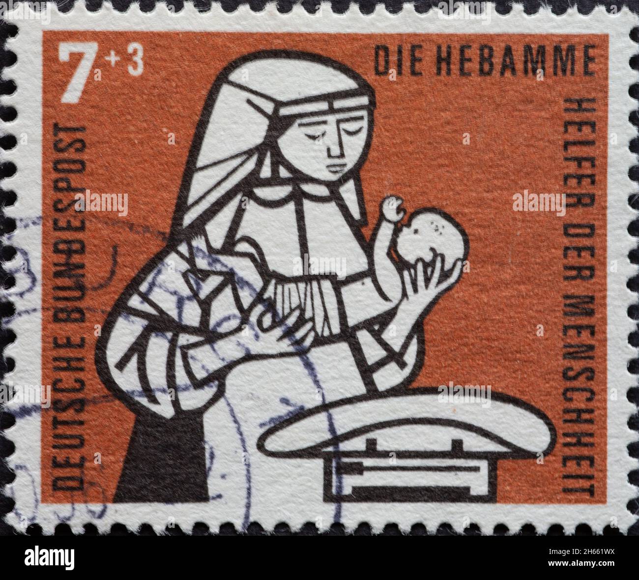 ALLEMAGNE - VERS 1956: Ce timbre-poste en marron montre une sage-femme avec un bébé au berceau comme aide de l'humanité.Vers 1956 Banque D'Images