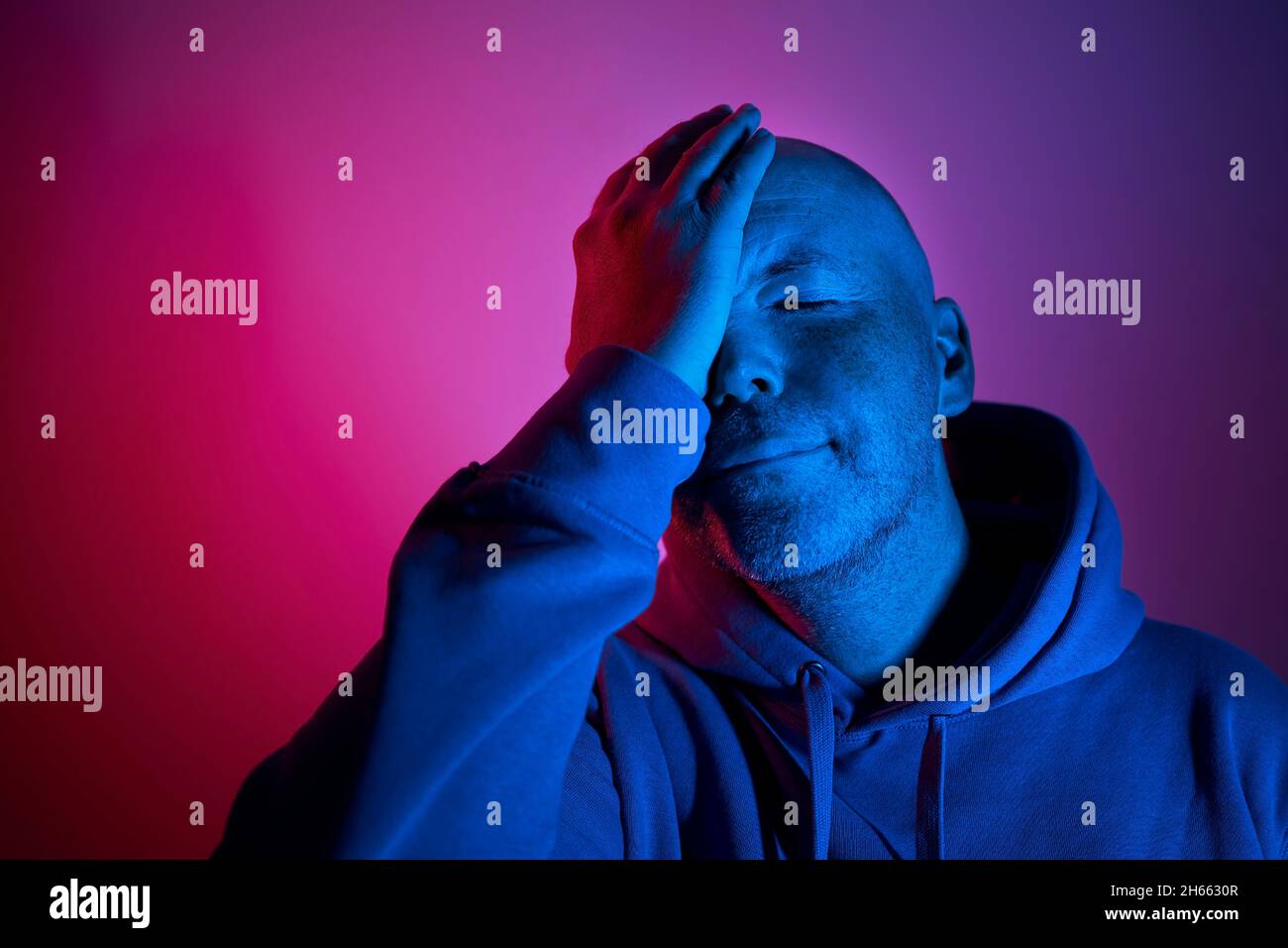 Portrait éclairé par un éclairage au néon.Gestuelle de l'homme d'âge moyen avec des lumières violettes et bleues. Banque D'Images