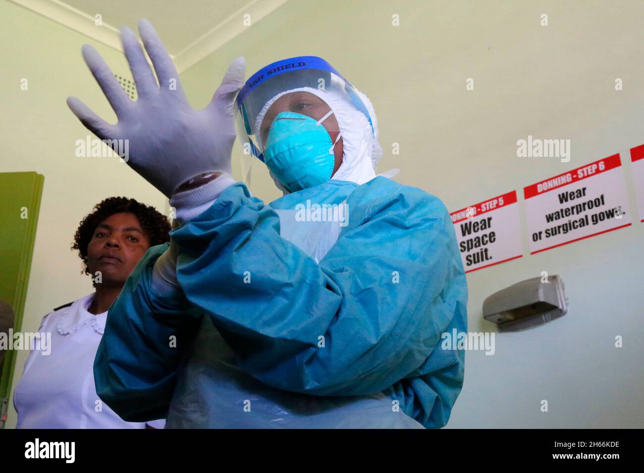 Une infirmière met des gants pour montrer comment elle traite les patients atteints du virus Ebola à l'hôpital Wilkins Harare.Zimbabwe. Banque D'Images