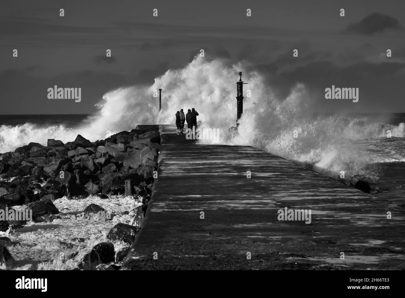 Storm Clara atteint la côte nord-irlandaise à Castlerock, en écrasant les vagues qui engloutissent le quai. Banque D'Images