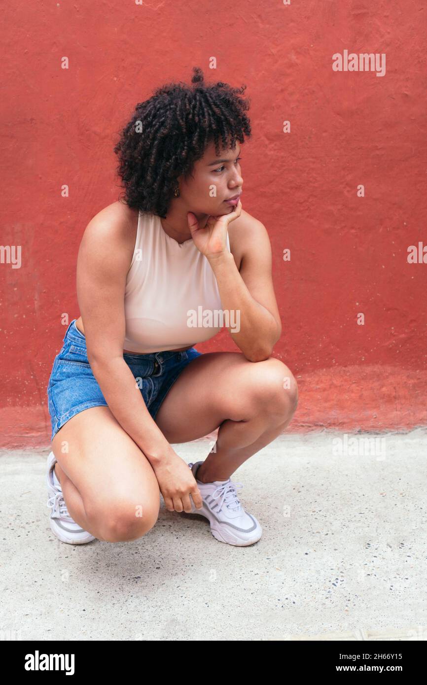 Belle femme mixte d'origine ethnique avec des croches de cheveux afro naturelles en toute confiance dans la rue. Banque D'Images