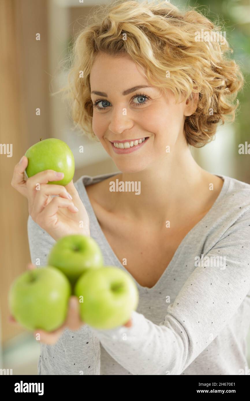 jeune femme tenant des pommes vertes Banque D'Images
