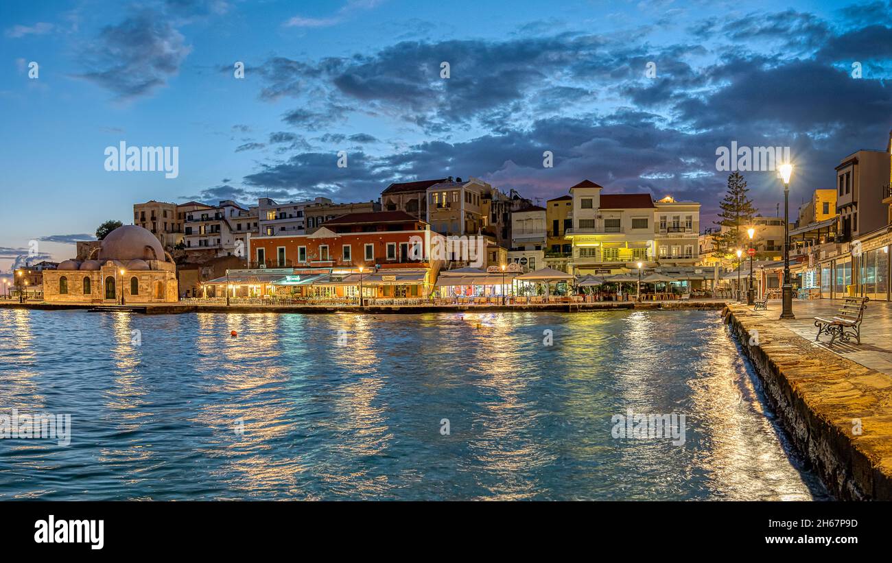 L'heure bleue dans le port de Chania avec des reflets dans la mer du ciel et des restaurants, Crète, Grèce, 13 octobre 2021 Banque D'Images