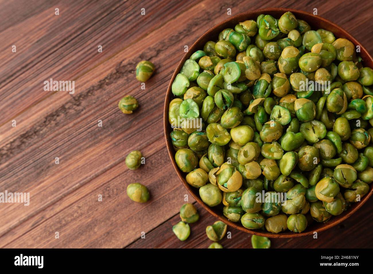 Vue de dessus des pois verts salés dans un bol en bois sur la table, plat, en-cas sains, nourriture végétarienne. Banque D'Images Vue de dessus des pois verts salés dans un bol en bois sur la table, plat, en-cas sains, nourriture végétarienne. Banque D'Images