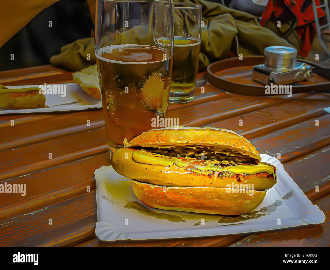 Délicieux hot dog à la saucisse blanche, avec beaucoup de moutarde, accompagné de bière pression, à l'happy hour, après une séance photo. Banque D'Images