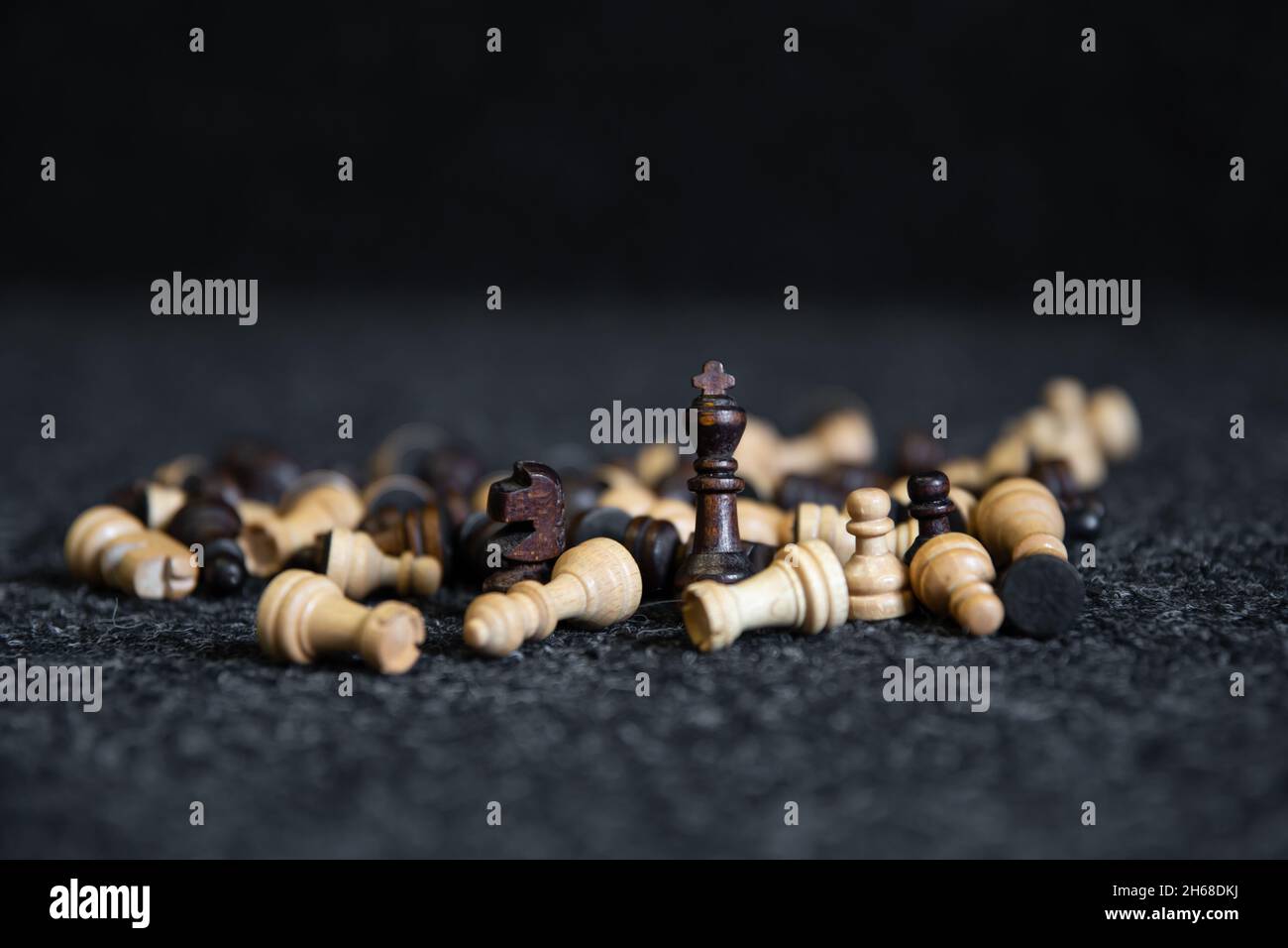 Pièces d'échecs dispersées sur un fond noir flou. Banque D'Images