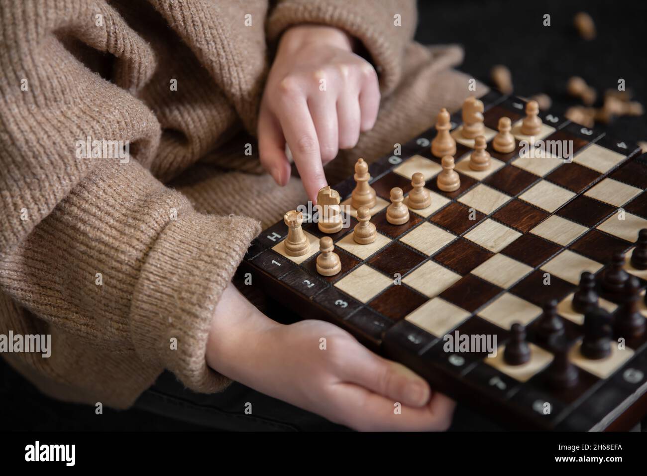 Femme plaçant des pièces d'échecs sur un échiquier. Banque D'Images