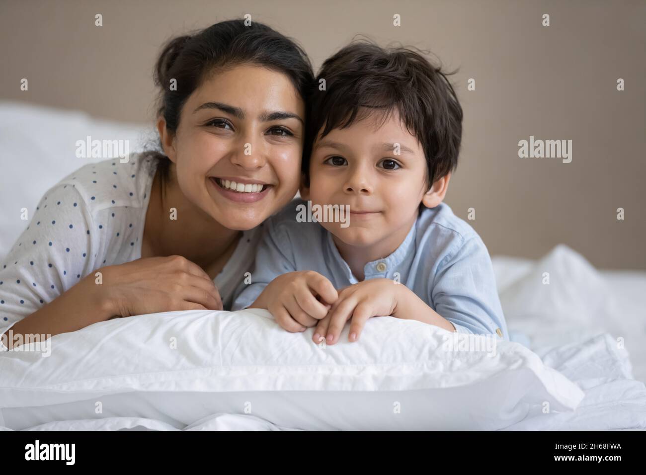 Joyeux maman et gamin indiens allongé dans du linge blanc Banque D'Images