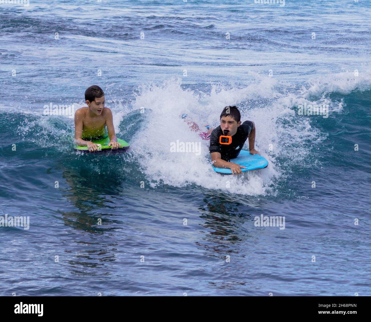 Honolulu, Hawaii - 6 novembre 2021 - les jeunes garçons jouent sur leurs planches de surf. Banque D'Images