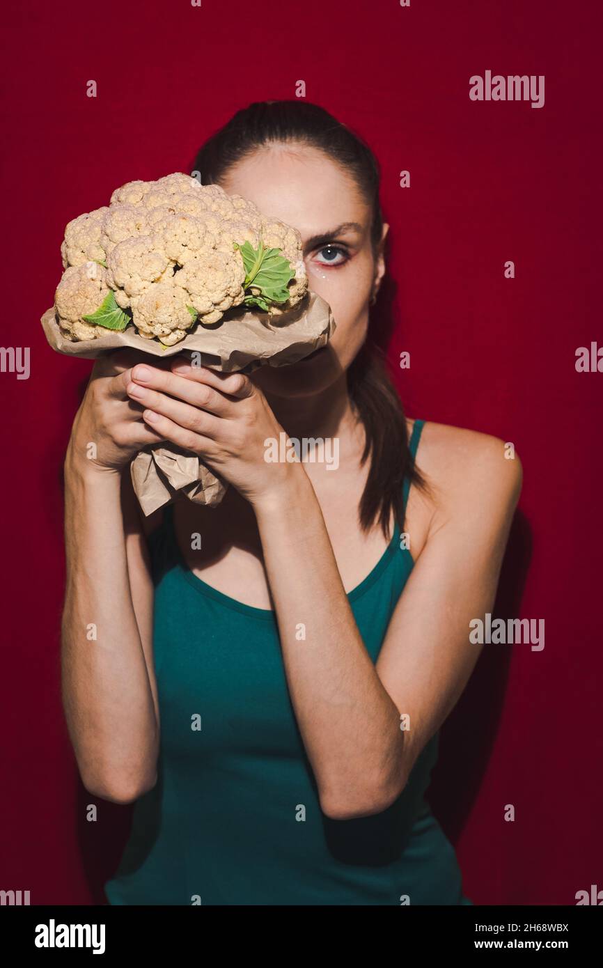 Modèle triché posant avec le chou-fleur. Banque D'Images